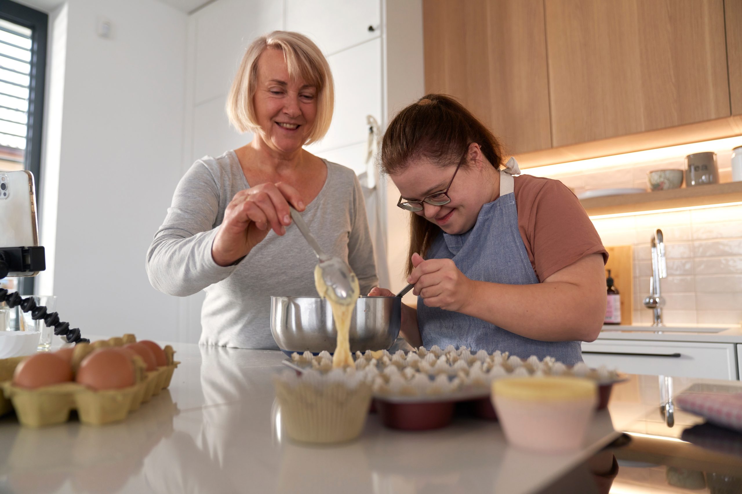 Down,Syndrome,Woman,And,Her,Mother,Making,Homemade,Cupcakes